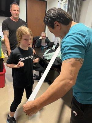 Hanshi giving Faith her white belt.