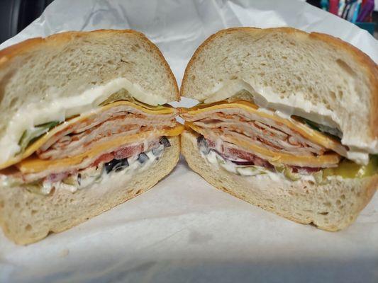 Sandwich with Santa Fe turkey, smoked cheese and jack cheeses, mayo, lettuce, tomato, onion, black olives, & pepperocinis.