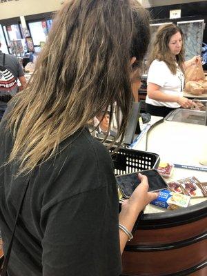 A woman unpacking her basket in the cashier line