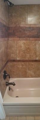 The oil rubbed bronze fixtures in the old tub with new tile.