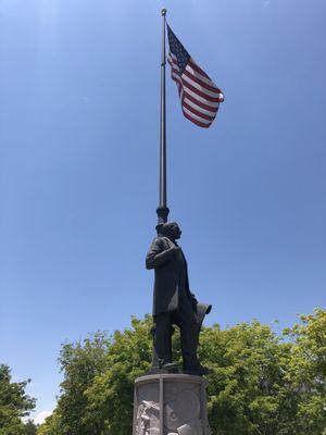 Monument and flag above the treetops