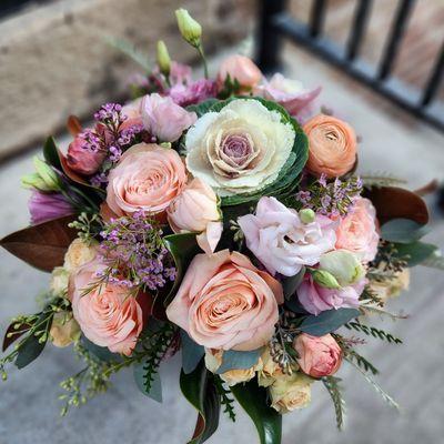 Blush fall color scheme, including kale, roses, spray roses, lisianthus, ranunculus and magnolia foliage.