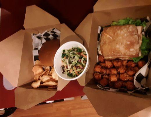 To-go orders are well packaged. Burger with kettle chips, handheld with sweet potato puffs, and coleslaw.