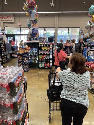 Jackknifed line at the single register that wraps to the left as well as down the aisle.