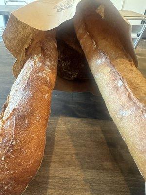 Two baguettes and a country loaf of sourdough bread