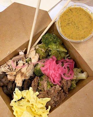 Large bowl with scrambled eggs, garlic mushrooms, double broccoli, mojo chicken, braised beef, pickled onions and peanut miso sauce.