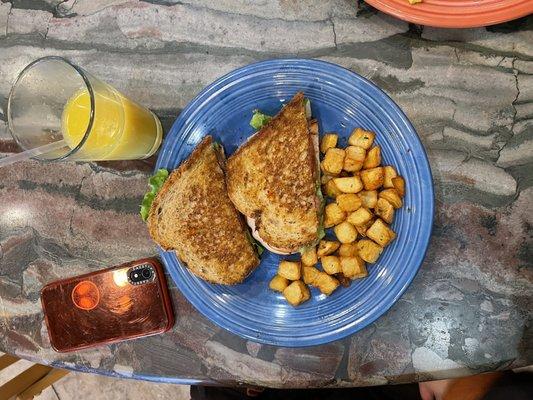 Potatoes and sandwich paired with orange juice