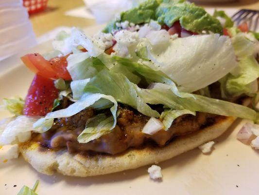 Huaraches with carnitas!  Eans, mean, lettuce, cheese, tomatoes and onions on top of a piece of masa.