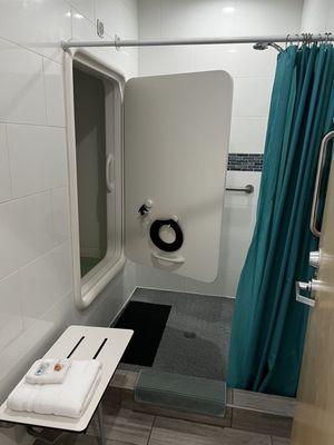 Room with shower, floating tub, and toiletries