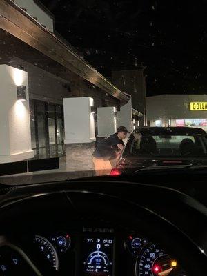 Employee talking to someone at their car, NOT a customer.