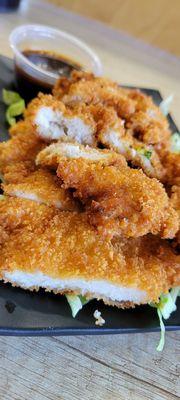 Boneless chicken breast breaded with Panko & fried. Served over lettuce & with a side on Tonkatsu (maybe not sure) sauce