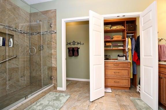 Louisville bathroom remodel featuring walk-in shower with frameless shower door, elegant tile flooring, updated closet storage and more...