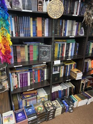 Books on spirituality, tarot cards, and the super natural are stacked from the floor to ceiling.