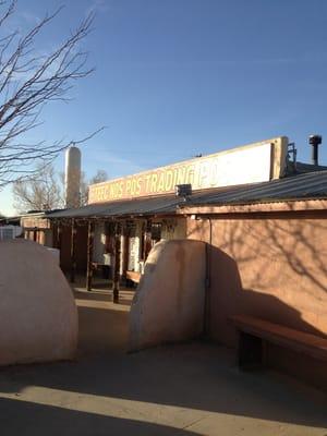 Front of the building, there's a gas station and feed store