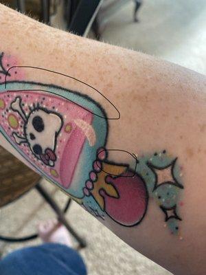 The black ink bleed which is also in Hello Kitty's whiskers.  Those spots are also extremely raised and permanently scarred.