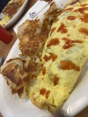 Omelette with hot sauce and hash browns