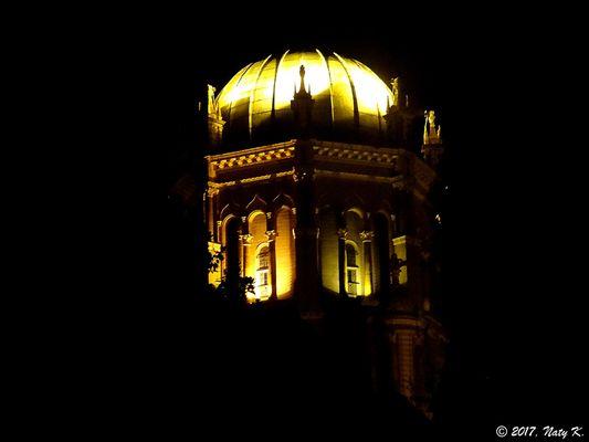 The dome of Memorial Presbyterian Church, lit at night.  The dome rises over 100 feet over your head and encompasses many religious symbols.