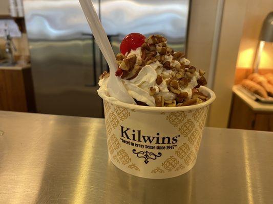 Hot fudge sundae with cherry ice cream, pecans, whipped cream and a cherry