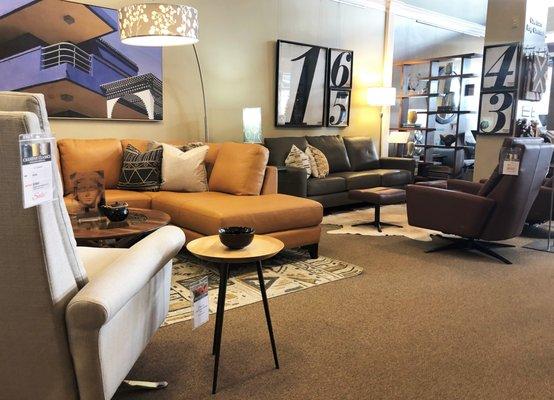 A view of some American Leather sofas and recliners and the Jameson side table by Charleston Forge.