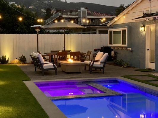 Landscape Logic designed and built this pool and spa with outdoor living, pavers, string lights, artificial turf, lights, drip irrigation.