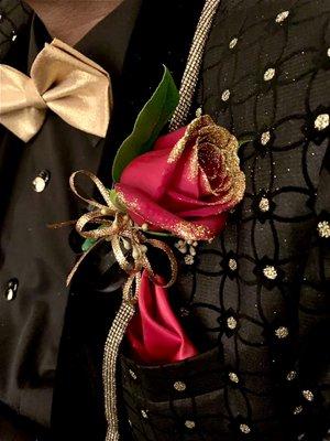 Red rose dipped in gold glitter boutonnière with gold and black trim.  He looked amazing and got compliments all night.