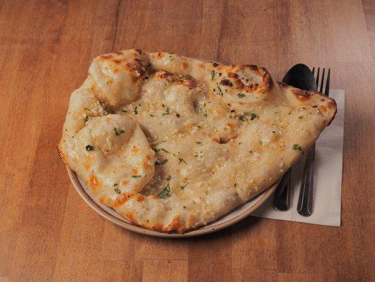 Spice up your day with our delicious Garlic Naan! Plunge into this irresistible delight!