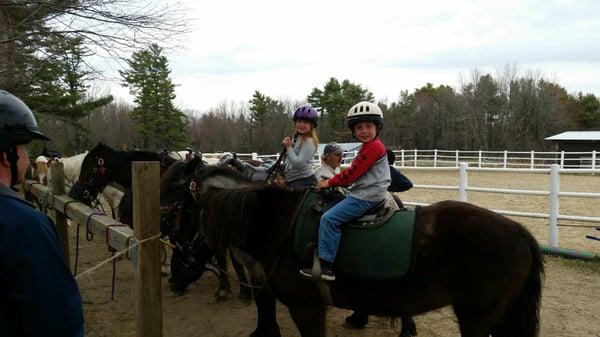 2 happy kids on ponies for a beginner trail ride.