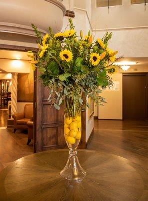 A large arrangement featuring sunflowers and orange lilies