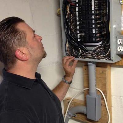 Cleveland home inspector Jay Brzezinski inspecting an electrical fuse panel.