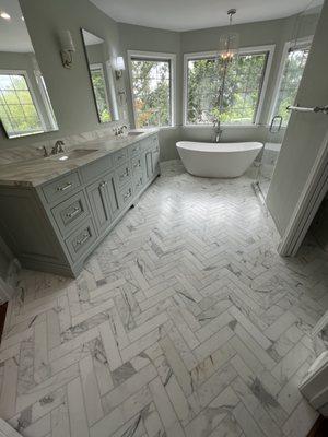 Master bathroom remodel. Including hand cut herringbone floor pattern, custom built vanity, freestanding tub, and full glass shower.