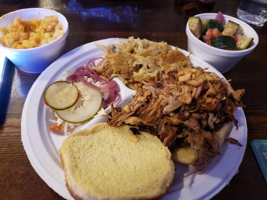 Pulled Pork sandwich with cheesy potatoes, cup sides of mac & cheese and cucumber & onion salad.