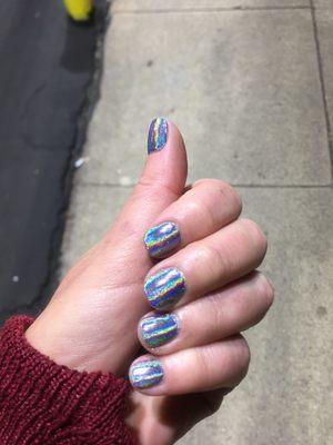 Black gel manicure with rainbow hologram powder on top.