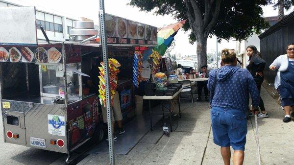 A cart comes daytime parked out front with hot food and snacks.