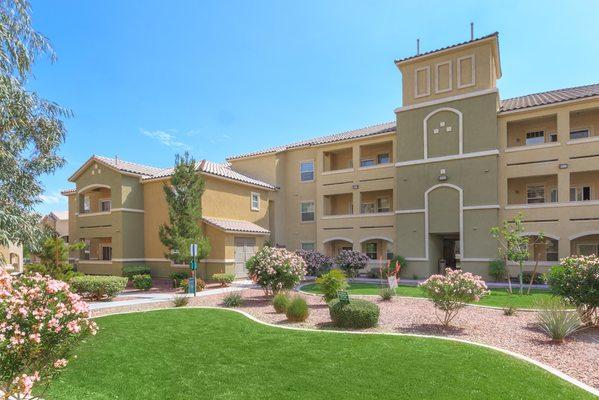 Community lawn with green grass and zero landscaping and view of balconies.