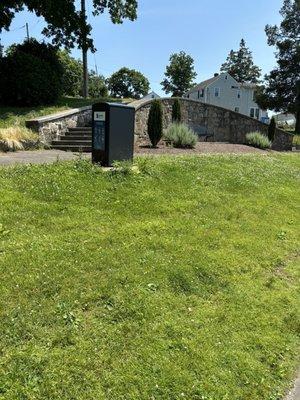 Walkway around lake with fountain, trash can