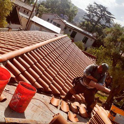 One of our roofers adding mortar to one of the many tiles we replaced on this roof.