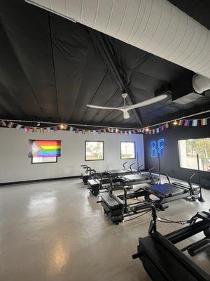 Reformers in the studio with pride flags and the big blue light up BF sign