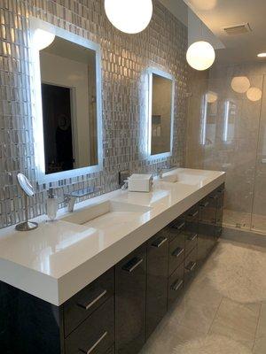 Cesar stone vanity counter top with custom sinks made from same quartz and glass mosaic backsplash.