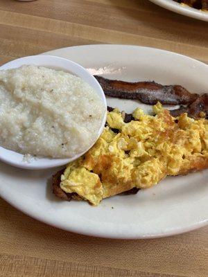 Scrambled cheese eggs, bacon and grits