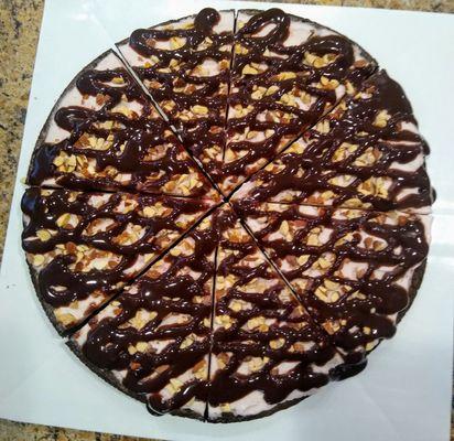 Custom ice cream pizza with strawberry ice cream, brownie cookie crust, chopped almonds and double hot fudge drizzles