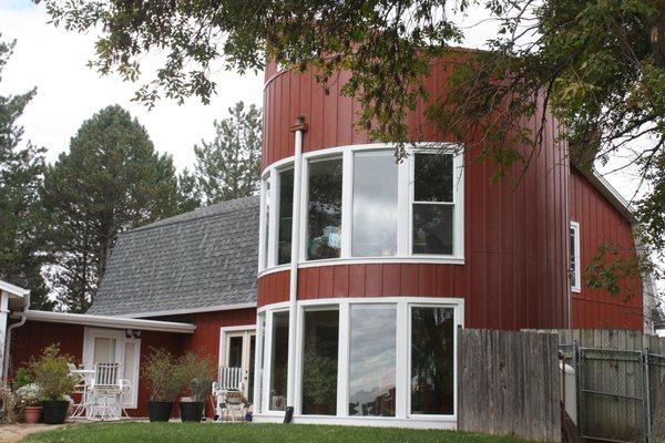 An old barn with a silo attached was converted into a house. We installed Steel Vertical Siding with Lindsay Windows