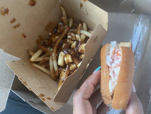 Half eaten lobster roll and poutine