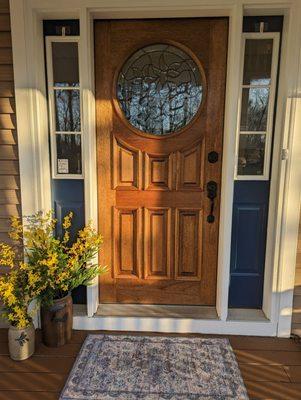 Mahogany door w/gorgeous round window. Casts beautiful shadows & prisms on entry wall. Accented w/ navy painted side lights (existing)