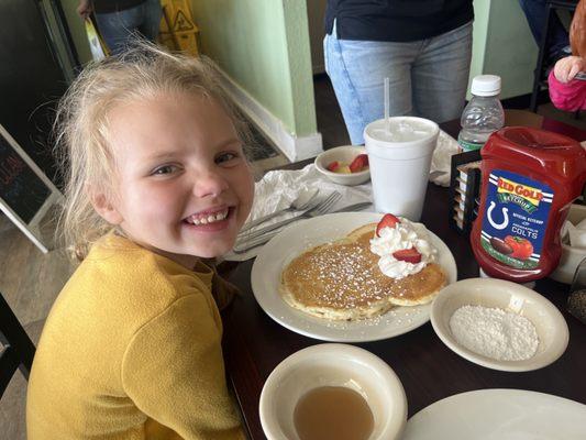 Smiling after the personal touch on her "Minnie Mouse" pancakes