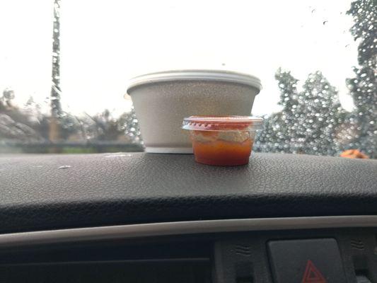 Tiny almost empty container of hot sauce.. egg drop soup behind