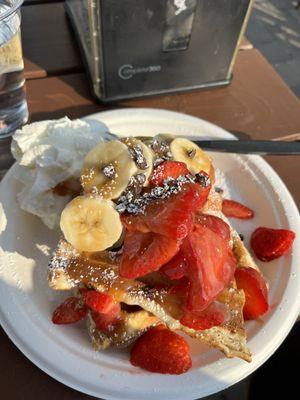 Berry banana waffle with chocolate chips and caramel drizzle.