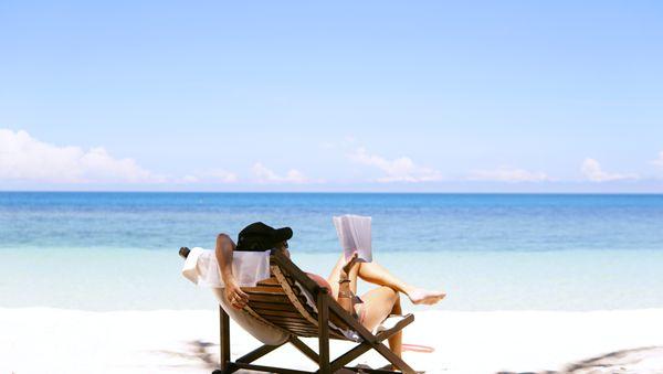 woman relaxing at the beach reading a book