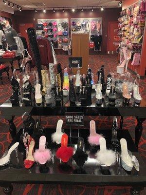 Table with stripper heels, and behind the party/games section and general store merch section (like t shirts, jackets, socks, etc.)