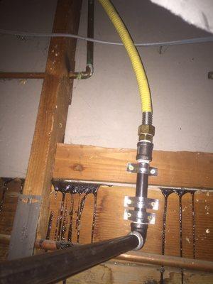 Gas line attached to studs inside cavity behind fireplace.