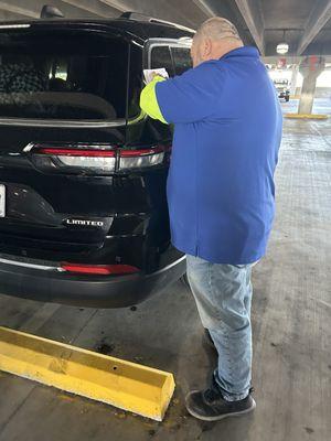 Damage to the vehicle in the Louisiana airport along with the employee who also made note of the damages.